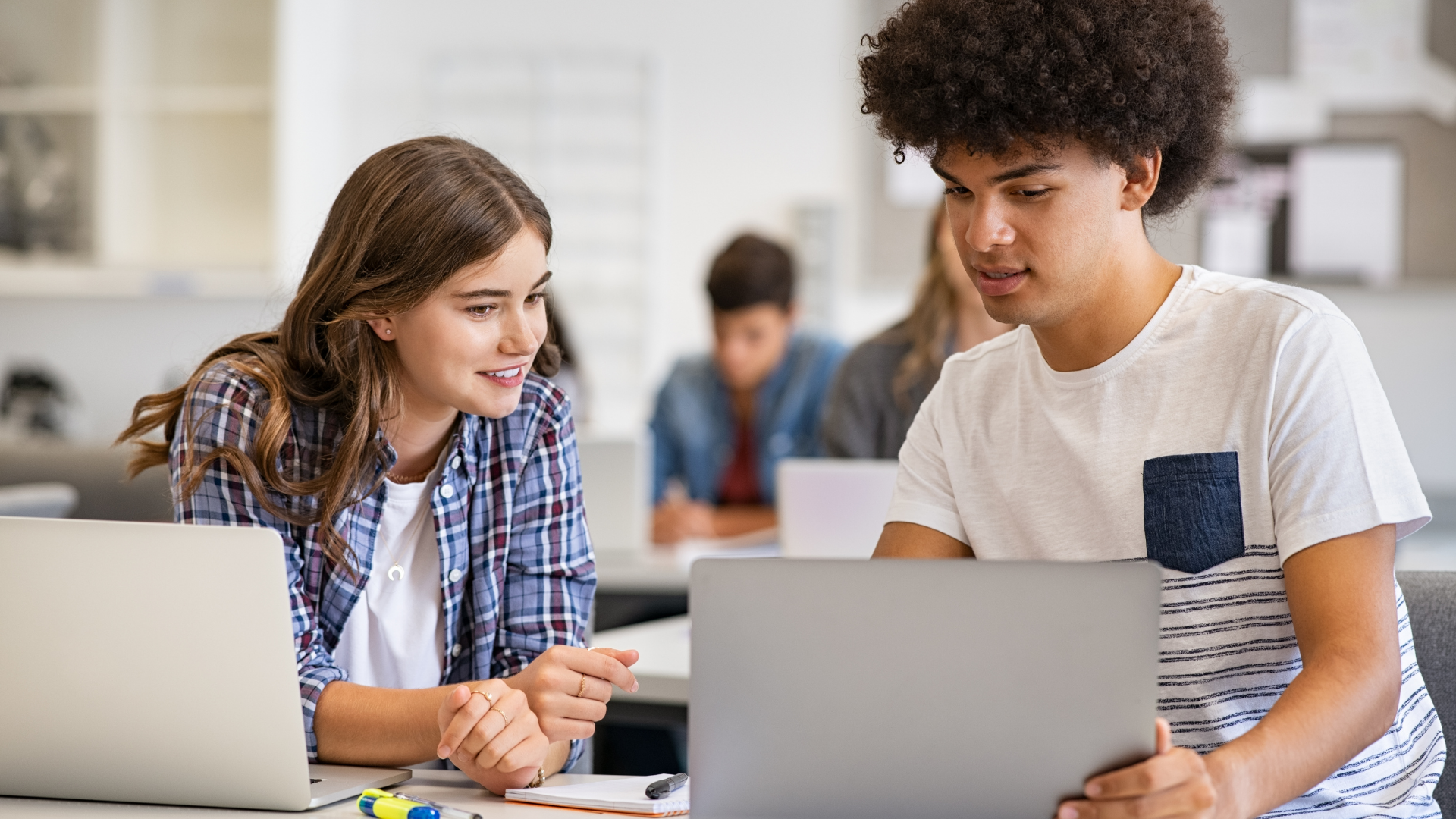 Twee leerlingen werken samen met laptop in klaslokaal – IT-reparatie Onderwijs door MicroFix voorkomt uitval en ondersteunt duurzaamheid.