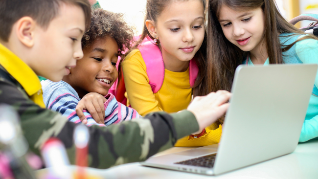 Basisschoolleerlingen werken samen aan laptop – IT-reparatie Onderwijs door MicroFix voorkomt uitval en verlengt levensduur
