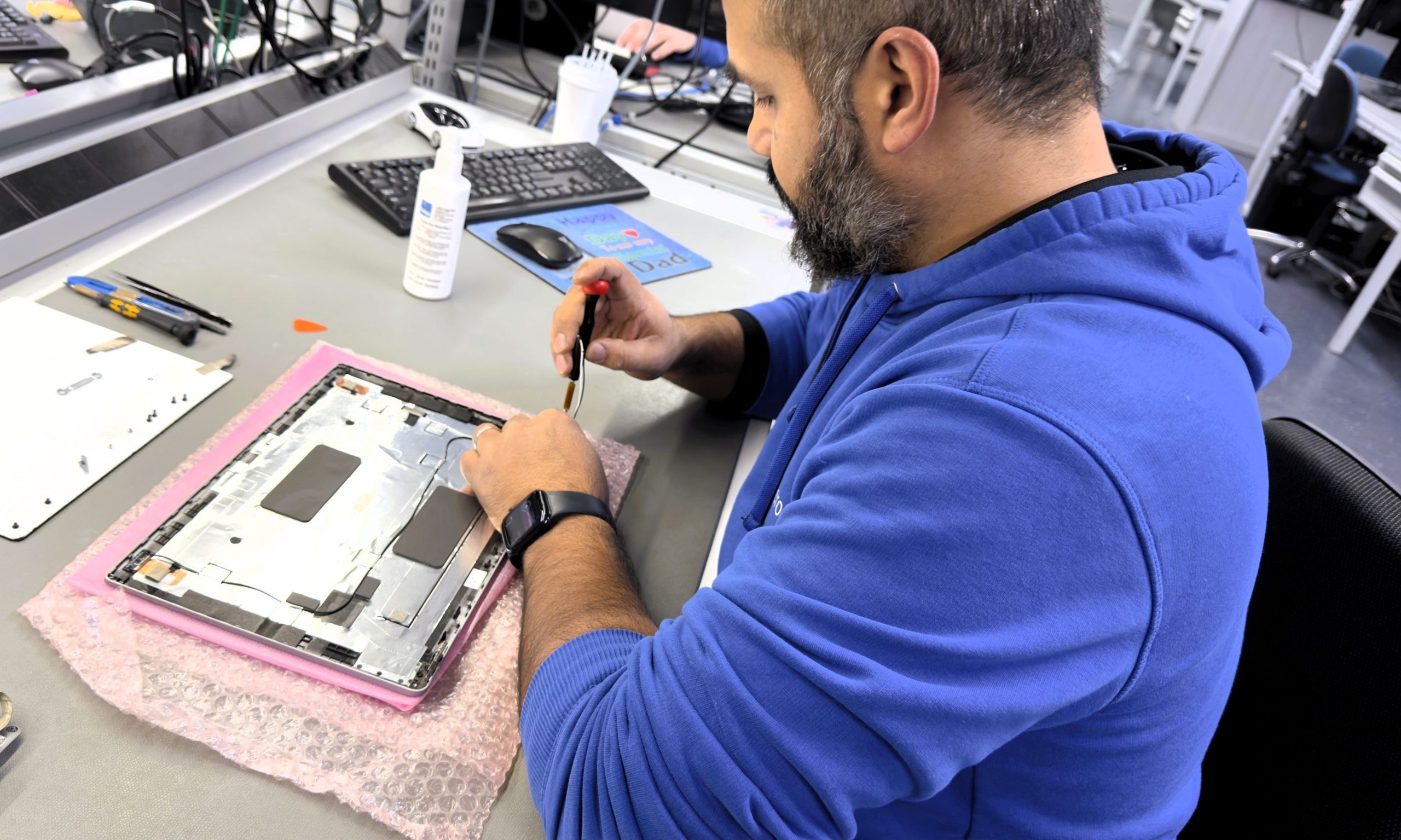 Close-up van een technicus die een laptop repareert: duurzame IT-oplossingen voor het verlengen van de levensduur en het verminderen van e-waste.